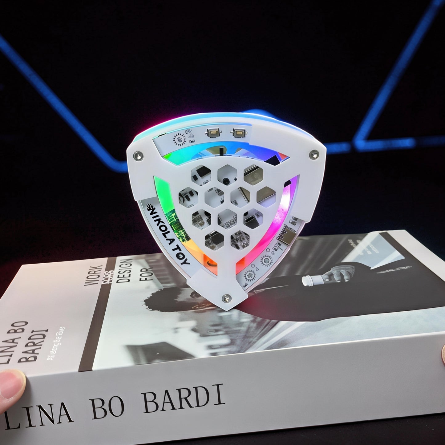 The Curious Mind Self-Balancing Lelo Triangle Kinetic Desk Toy with RGB LED lights, made of white ABS plastic.