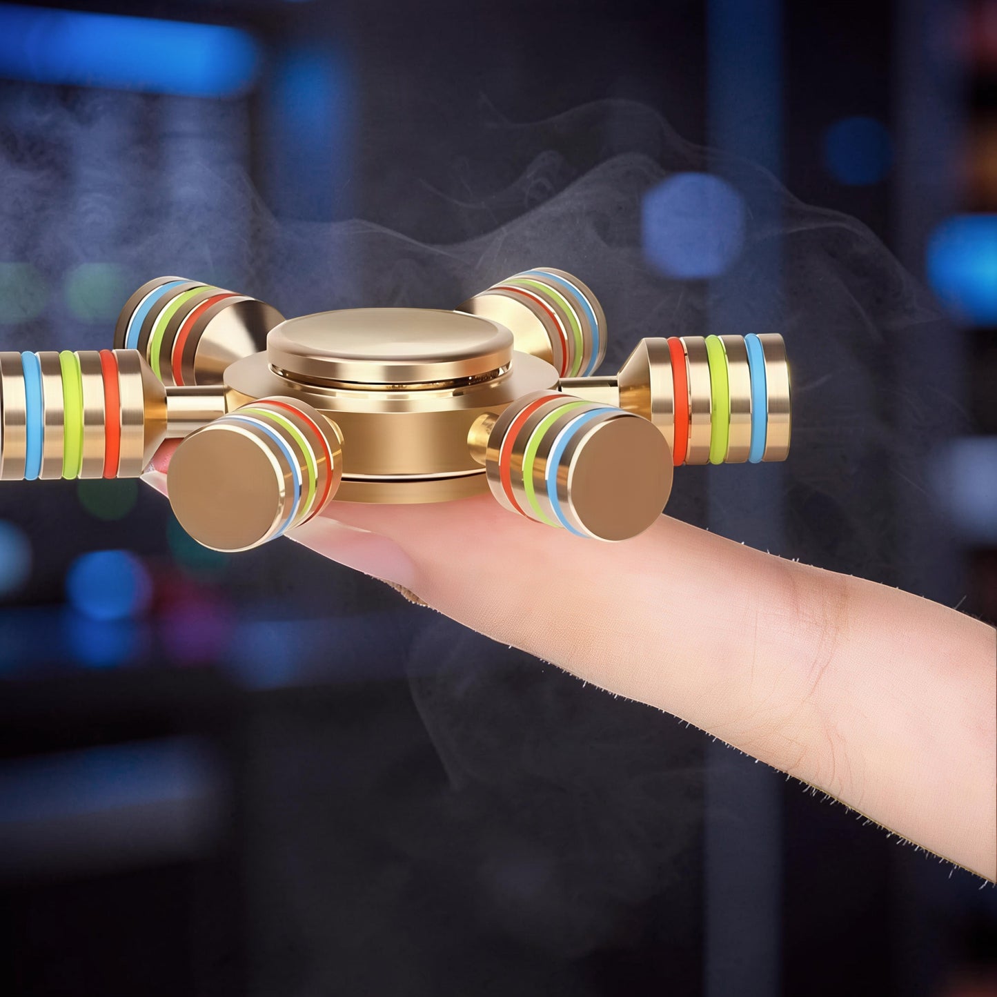 The Curious Mind Rainbow Metal Hand Spinner with gold finish and colorful bands on arms, held on a finger.