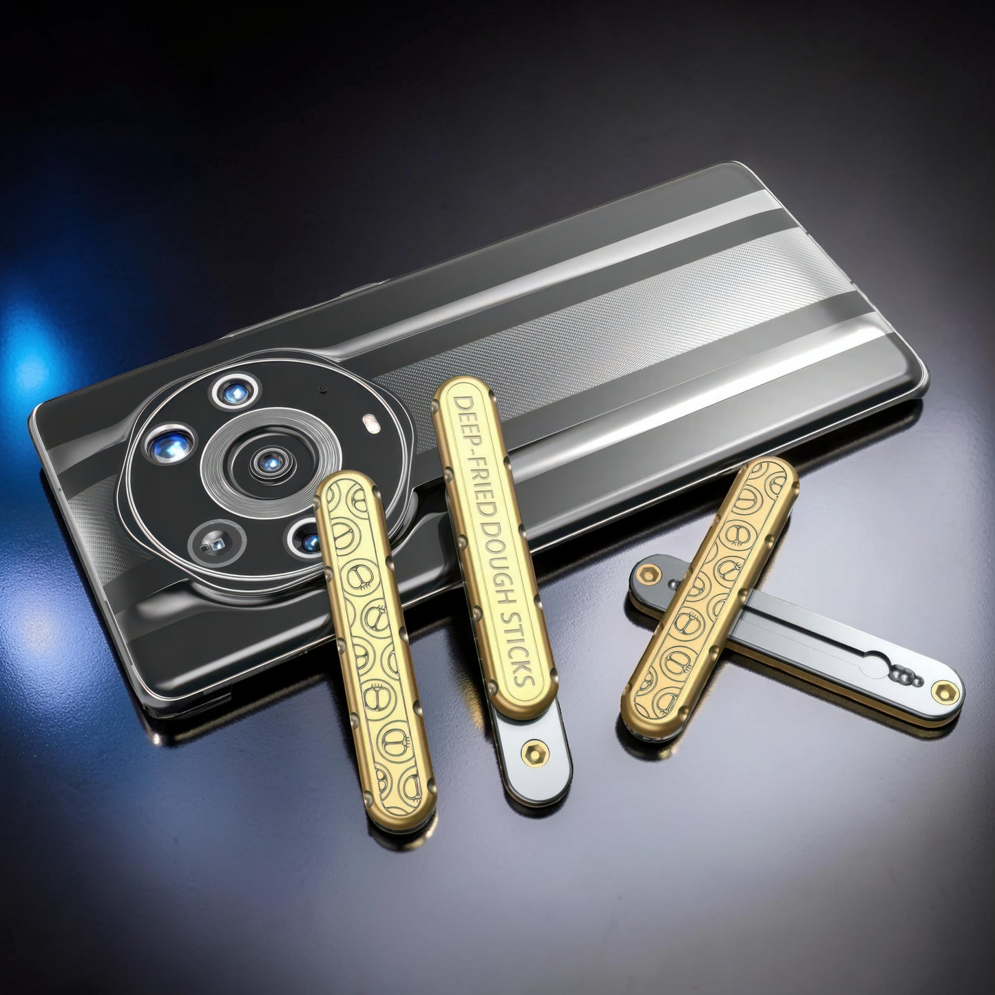 The Curious Mind Deep-Fried Dough Stick magnetic slider fidget toy in gold with engraved smiley faces and text. Sleek metal design.