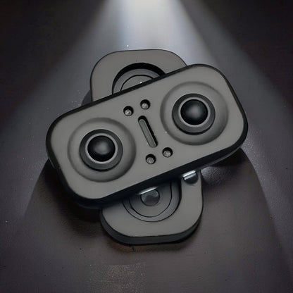 The Curious Mind Owl Push Slider, a compact black metal fidget toy with two circular buttons and a central slider.