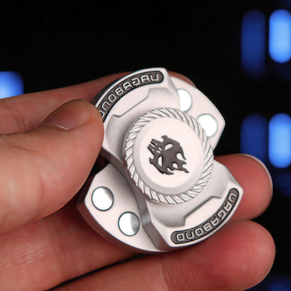 The Curious Mind Butterfly Plus Metal Spinner in black with a skull emblem and 'VAGABOND' text. Features smooth rotation for EDC.