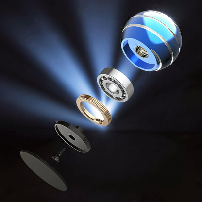 The Curious Mind high-gloss blue metal desktop stress ball, exploded view showing internal bearing and components.