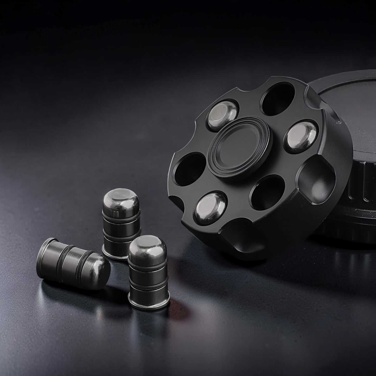 The Curious Mind Brass Finger Gyro Spinner with bullet-shaped weights, black metal, revolver cylinder design.