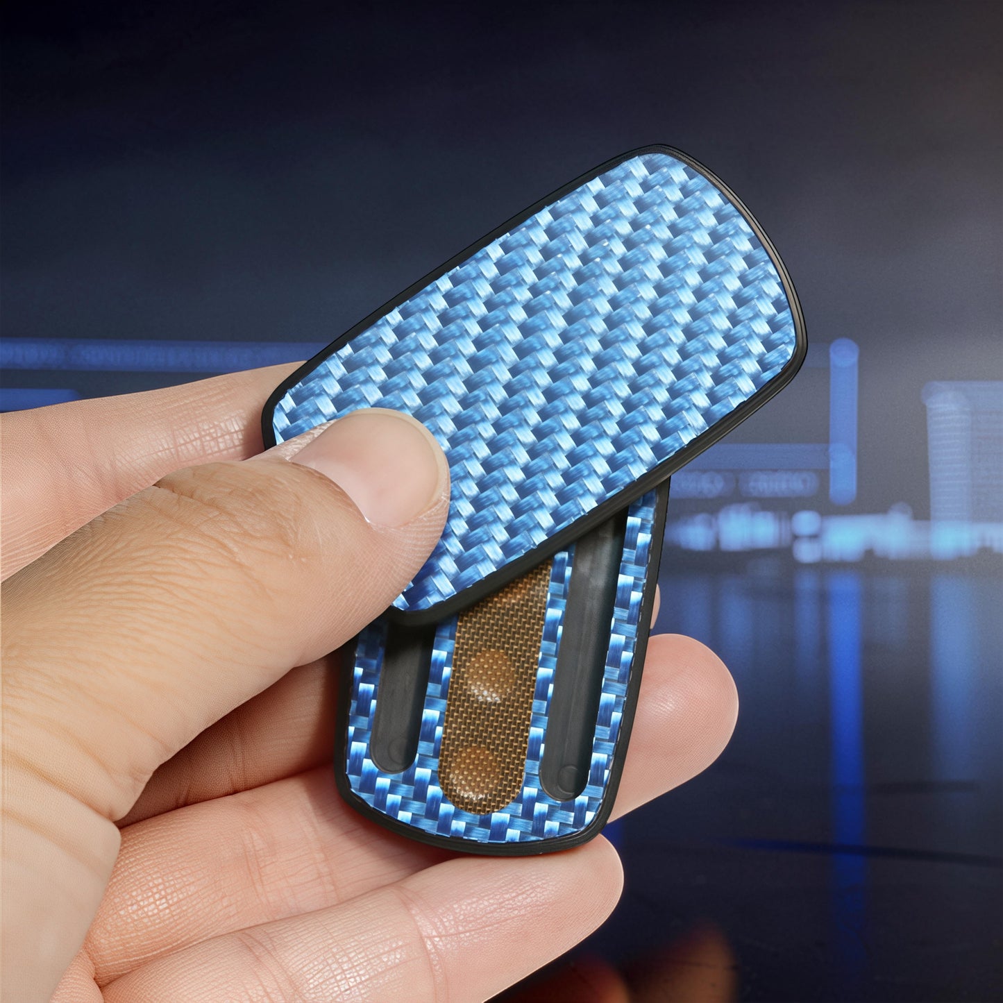 The Curious Mind Carbon Fiber Magnetic Slider fidget toy with blue weave pattern, held in hand.