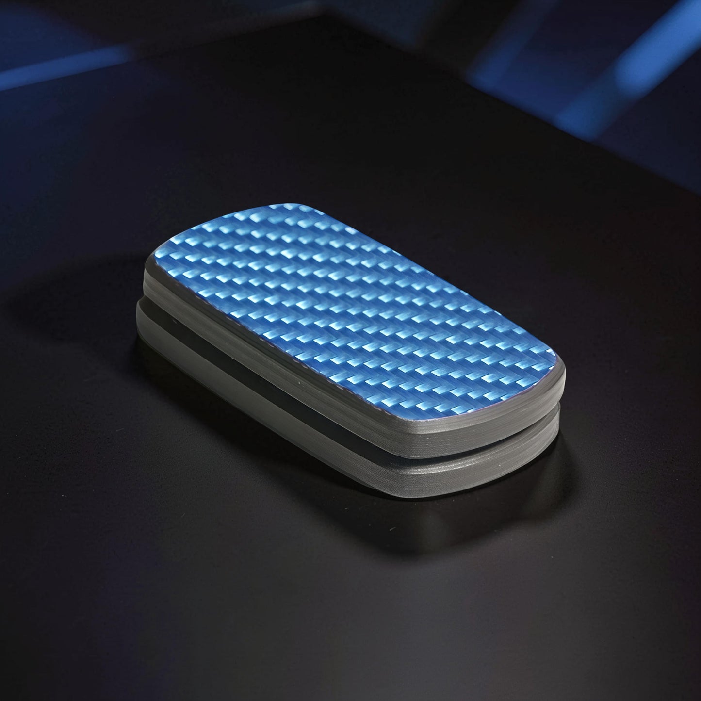 The Curious Mind Carbon Fiber Magnetic Slider fidget toy with blue textured top and grey sides.