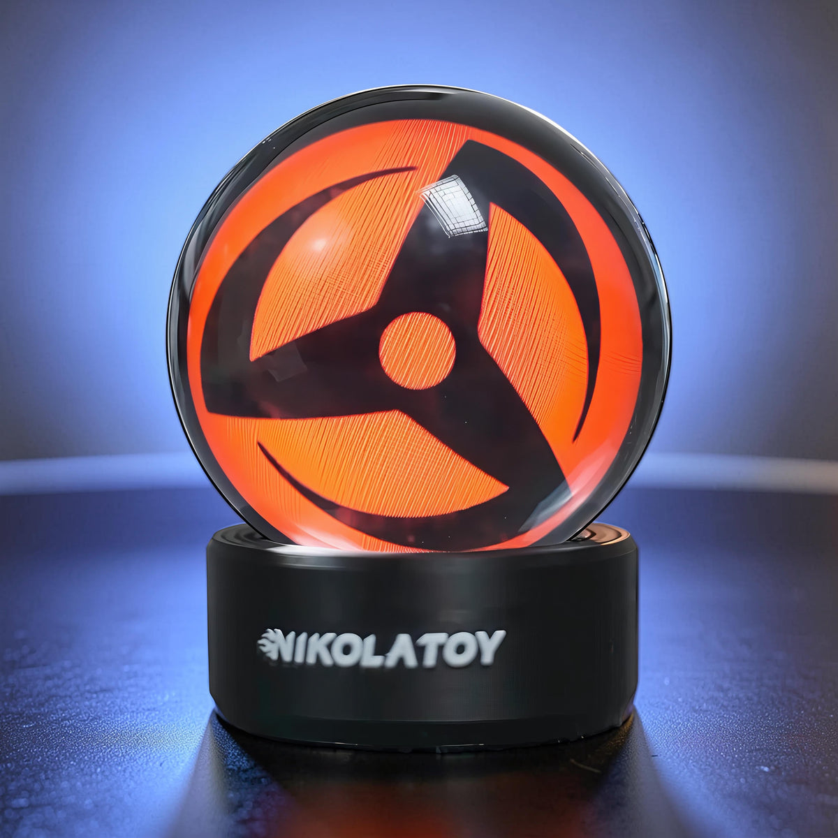 The Curious Mind Crystal Ball Decorative Ornament with orange and black design on a black base.