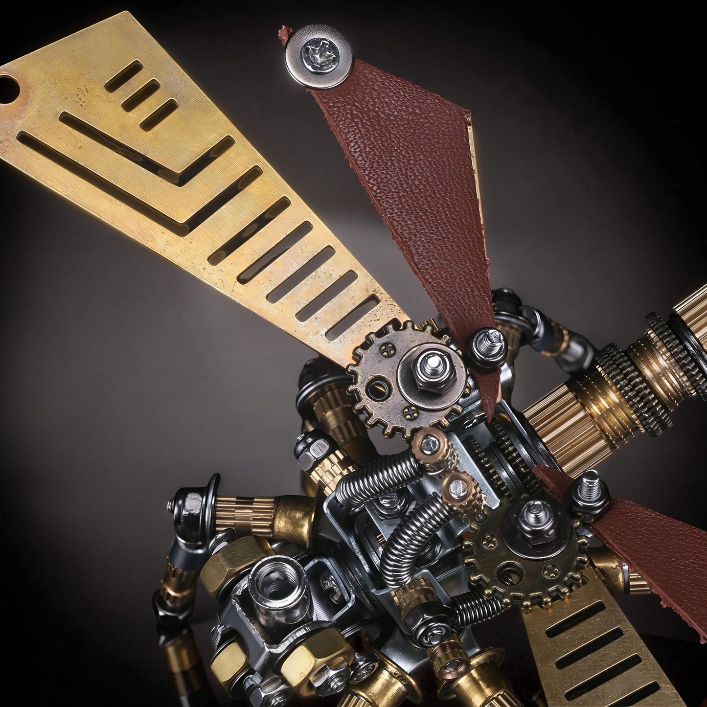 The Curious Mind Dragonfly premium 3D metal model kit, featuring intricate brass and steel gears, springs, and leather accents.