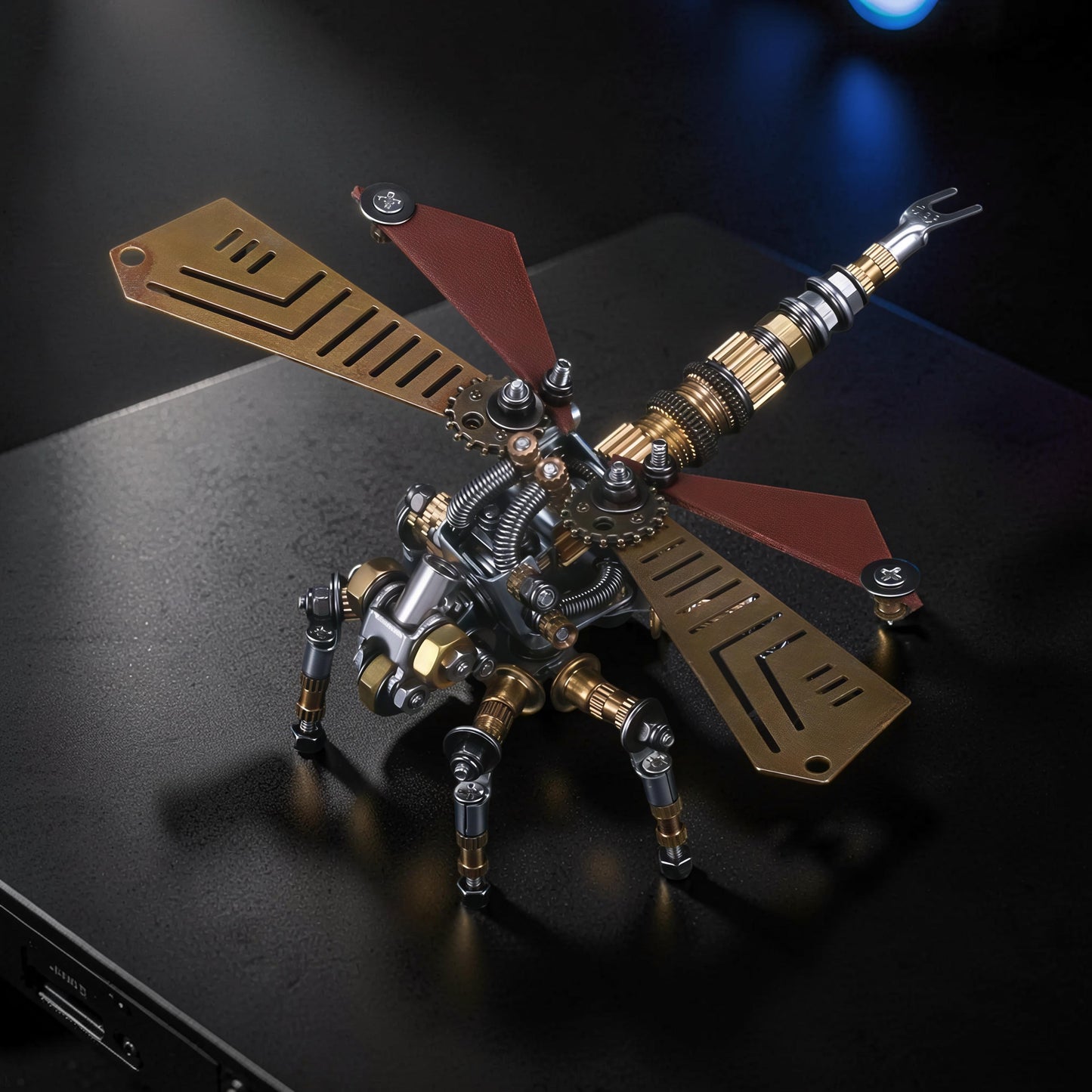 The Curious Mind Dragonfly premium 3D metal model kit with brass wings and red accents, featuring intricate gears and mechanical details.