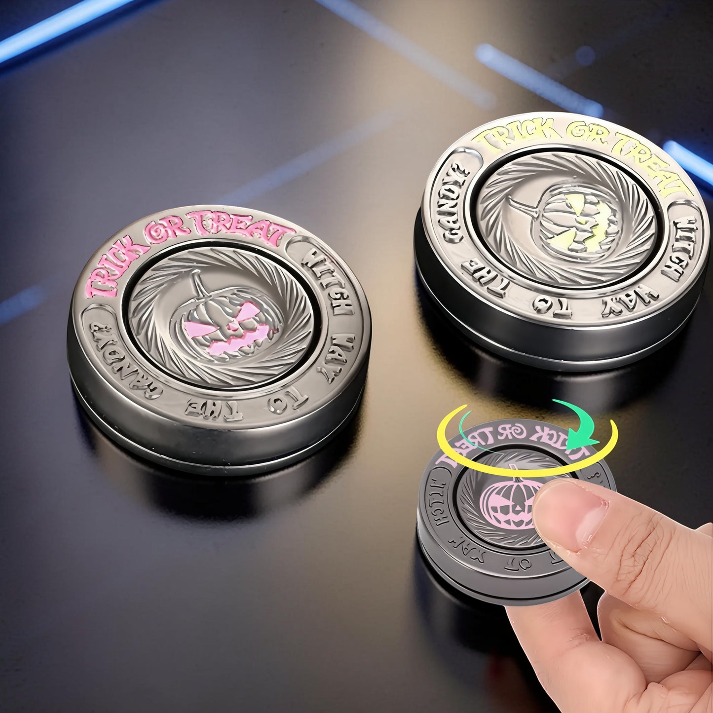 The Curious Mind Evil Pumpkin Haptic Coin Spinner with pink accents and "Trick or Treat" text. Metal EDC fidget toy.