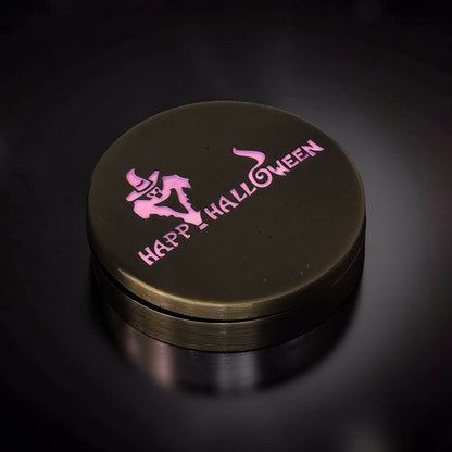 The Curious Mind Evil Pumpkin Haptic Coin Spinner with pink "Happy Halloween" text and ghost graphic on a dark metallic surface.
