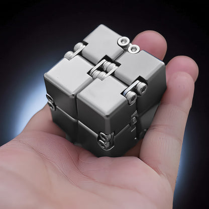 The Curious Mind Unlimited Magic Fidget Cube, a compact metallic grey desk fidget toy with a satisfying cube shape and magnetic joints.