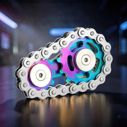 The Curious Mind Gear Chain Sprocket Spinner features a rainbow iridescent metal finish and silver chain. This fidget toy is designed for smooth rotation and focus.