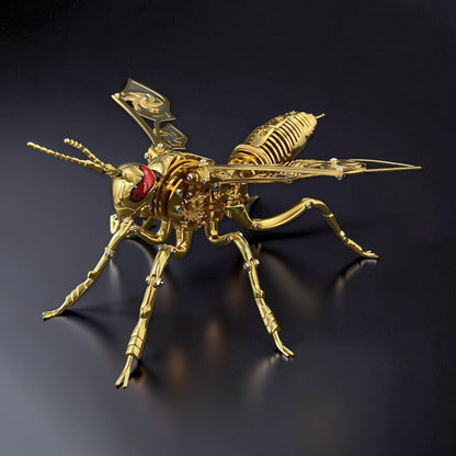 The Curious Mind Stainless Wasp 3D metal model kit, gold finish, intricate mechanical design with red eyes and detailed wings.