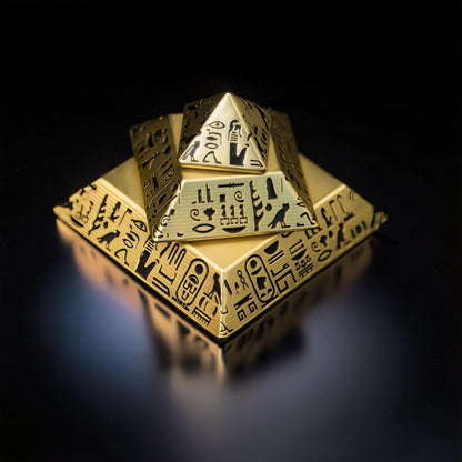 The Curious Mind gold pyramid desk spinner with Egyptian hieroglyphs. Metal construction, balanced for smooth rotation.