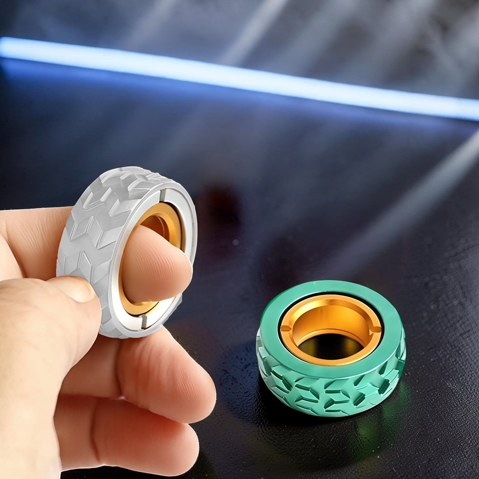 The Curious Mind Tire Haptic Ratchet Ring in silver and green metal with gold inner ring, tire tread design.