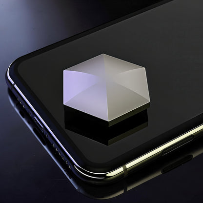 The Curious Mind Flipo Flip Hexagon kinetic desk spinner, a weighted metal geometric toy with a polished silver finish, shown on a smartphone.