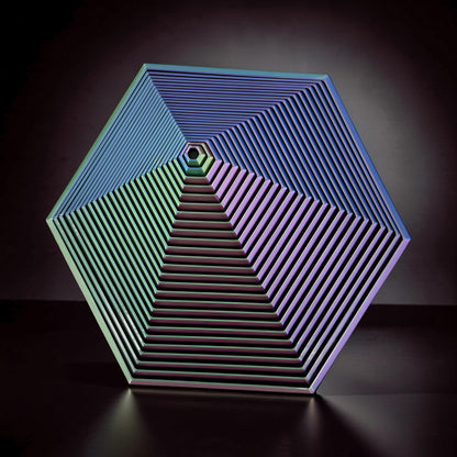 The Curious Mind Hexagon Push Fidget sensory toy with iridescent blue, green, and purple hues, featuring concentric hexagon layers.