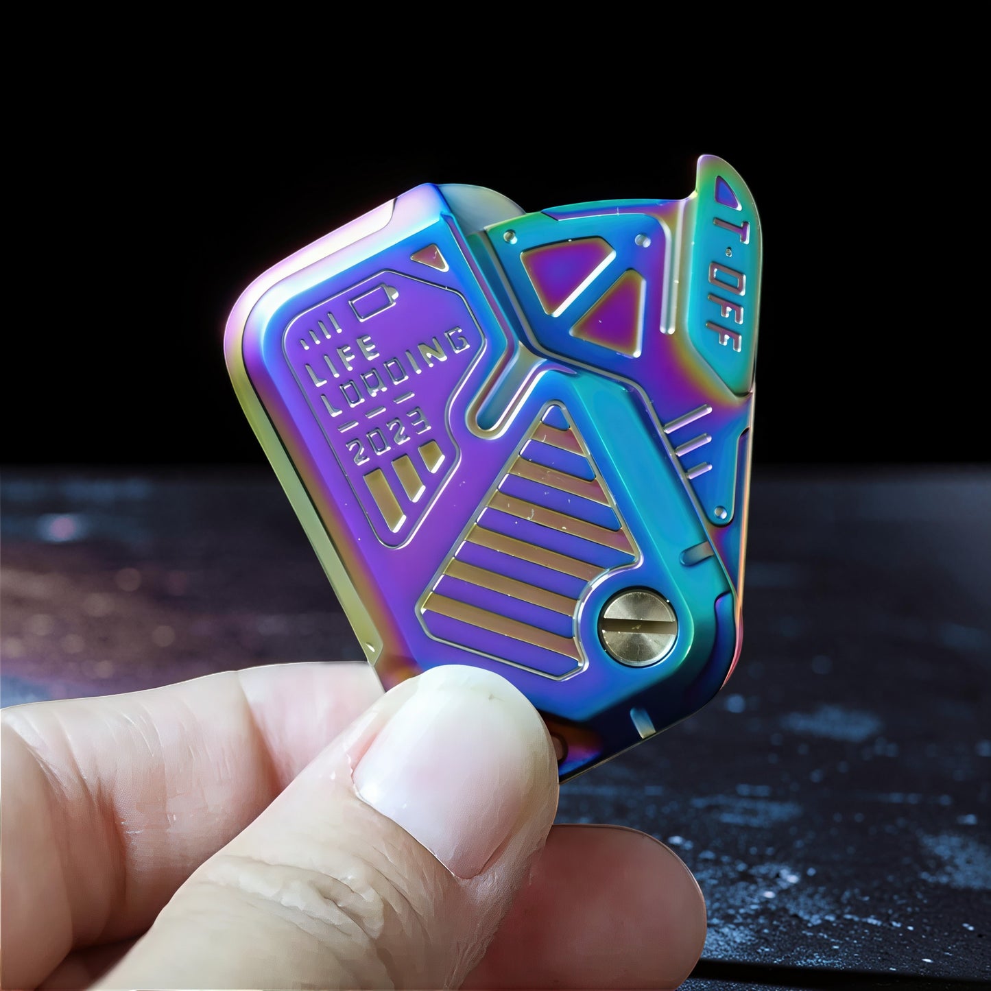 The Curious Mind Iridescent Chip Slider fidget toy with "LIFE LOADING 2023" text, made of metal with a push-and-return action.