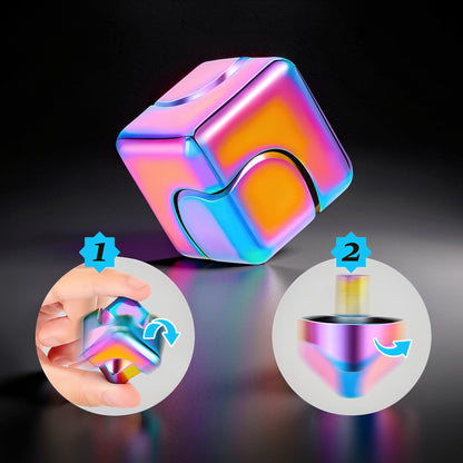 The Curious Mind Iridescent Spinner Cube fidget toy, a metallic cube with shifting pink, blue, and yellow colors, designed for desk play and stress relief.