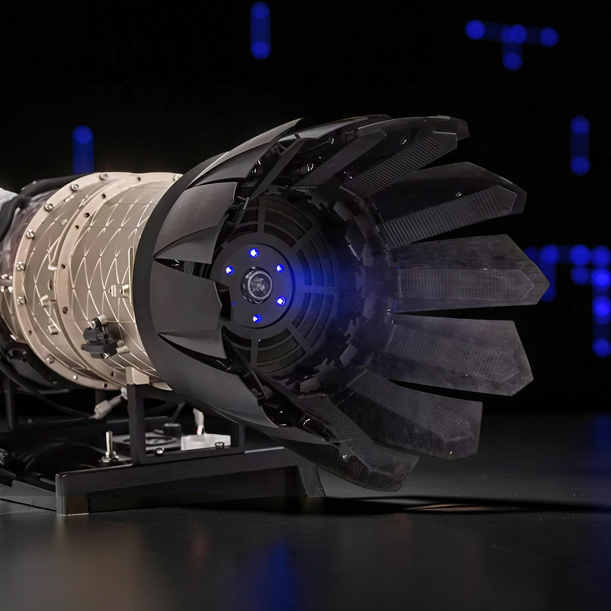 The Curious Mind Fighter Jet Turbofan DIY Kit model with black and beige PLA parts, featuring blue LED lights.