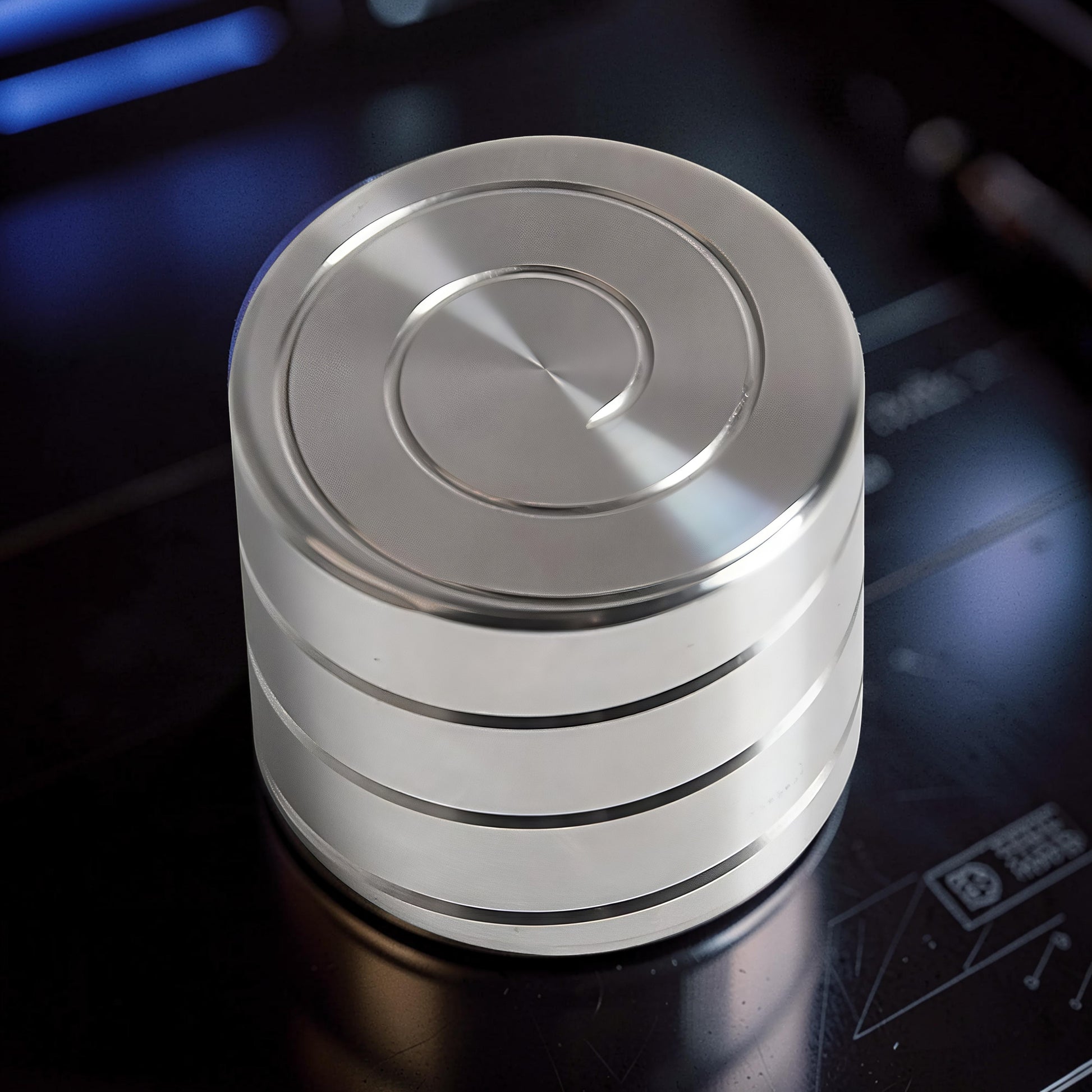 The Curious Mind Vortecon kinetic desk spinner is a premium, weighted metal desk toy with a spiral design on top and stacked rings on the side.