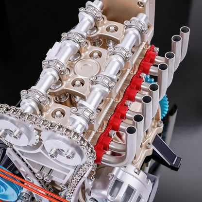 The Curious Mind L4 four-cylinder engine model kit, made of metal, with silver and gold accents, red detailing, and visible gears and chain.