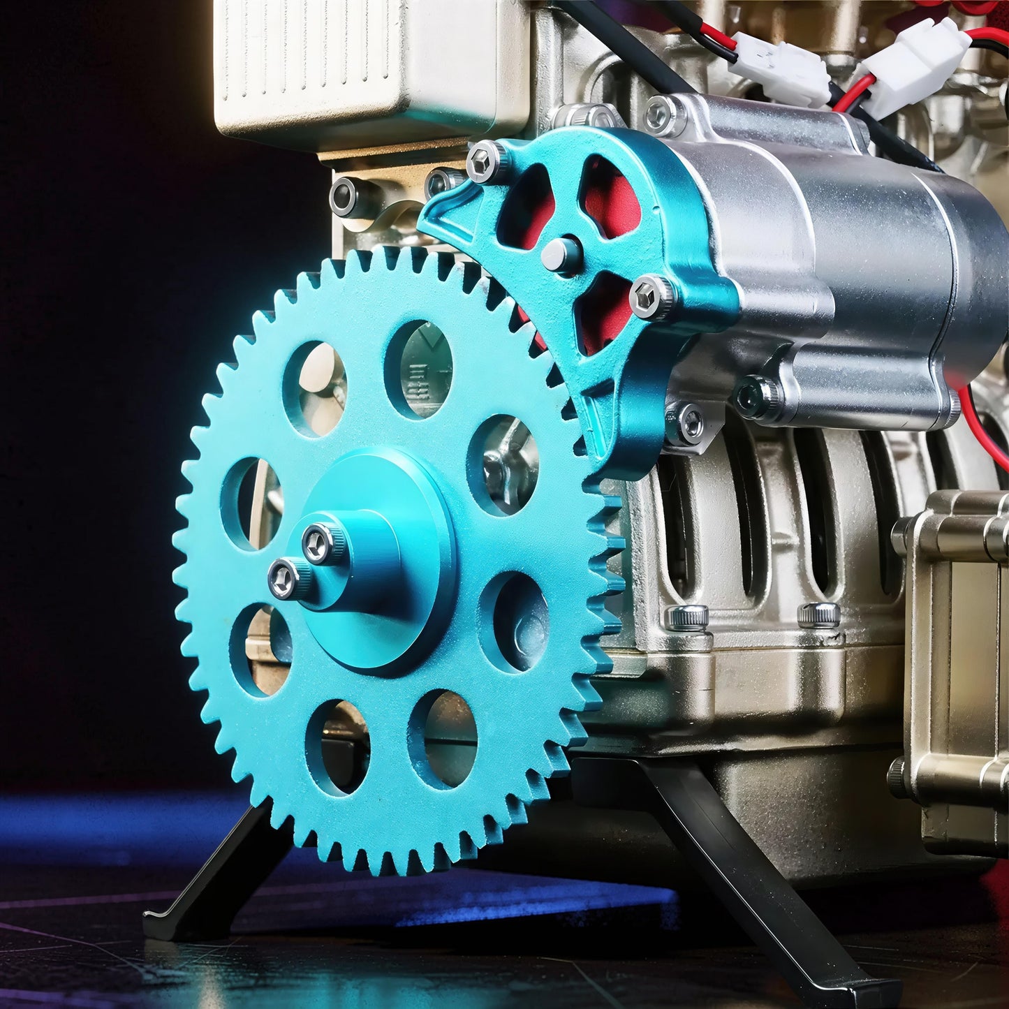 The Curious Mind L4 Four-Cylinder Engine DIY Kit, a detailed metal mechanical model with a prominent blue gear and silver engine components.