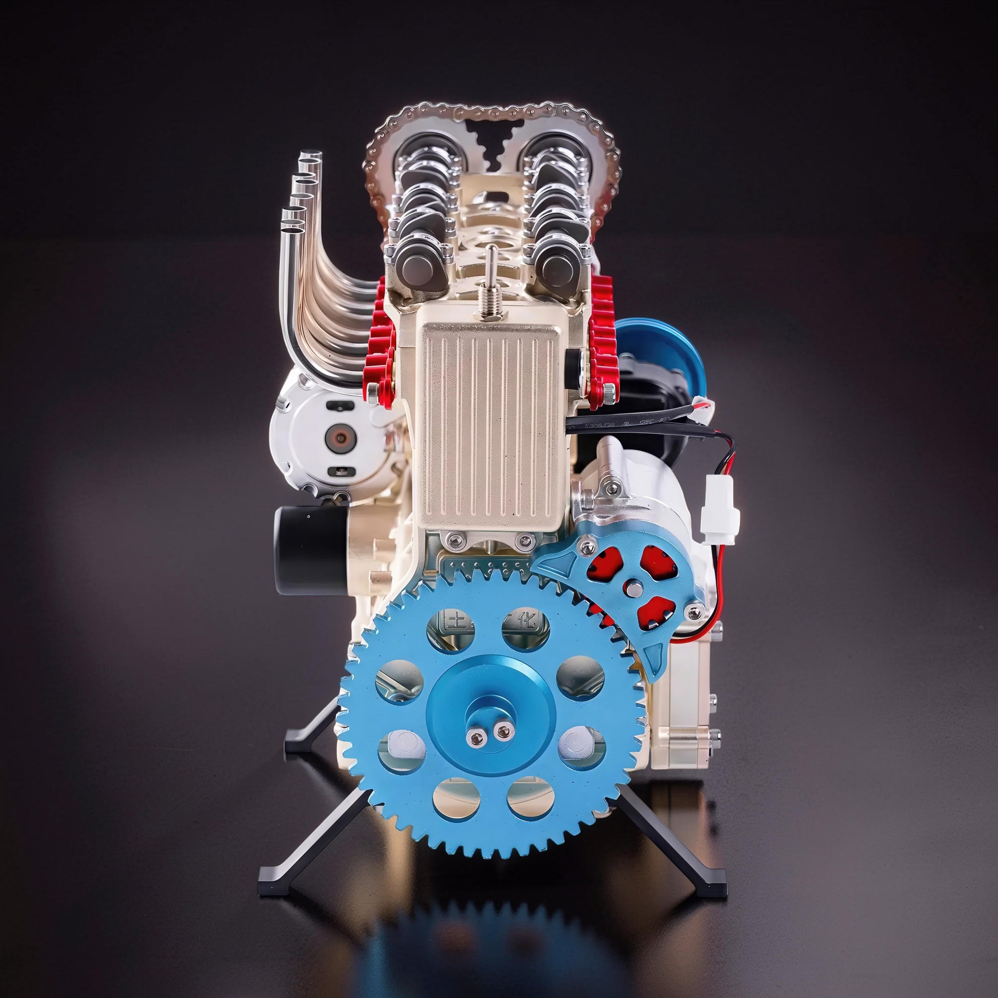 The Curious Mind L4 four-cylinder engine model kit, a detailed metal mechanical model with blue and red accents, displayed on a stand.