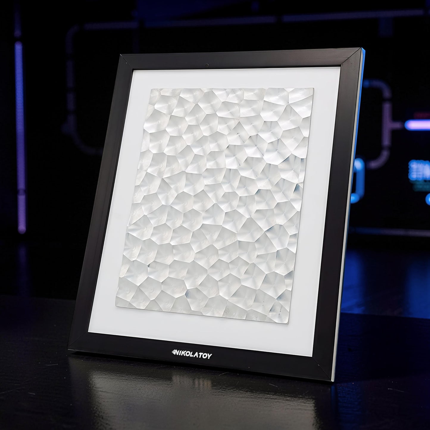 The Curious Mind Laser Light Effect Art Frame with a geometric, textured white surface in a black wood frame.