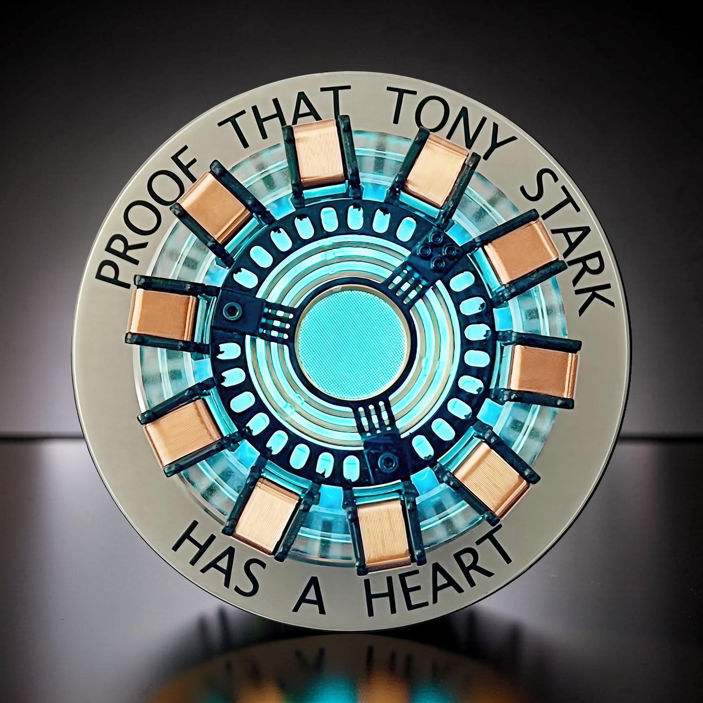 The Curious Mind Maglev Iron Man Ark Reactor Flagship HUD Edition, a metal desk object with a glowing blue center and copper accents.