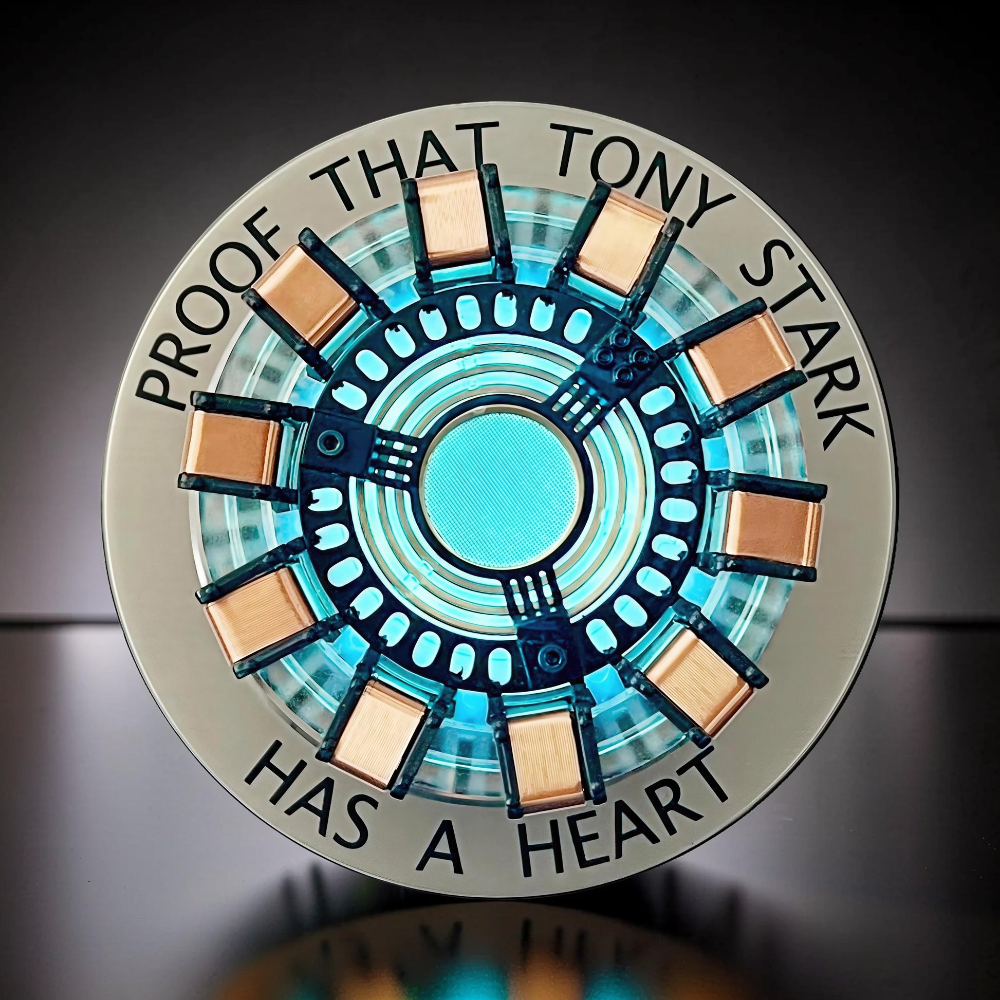 The Curious Mind Maglev Iron Man Ark Reactor Flagship HUD Edition, a metal desk object with a glowing blue center and copper accents.