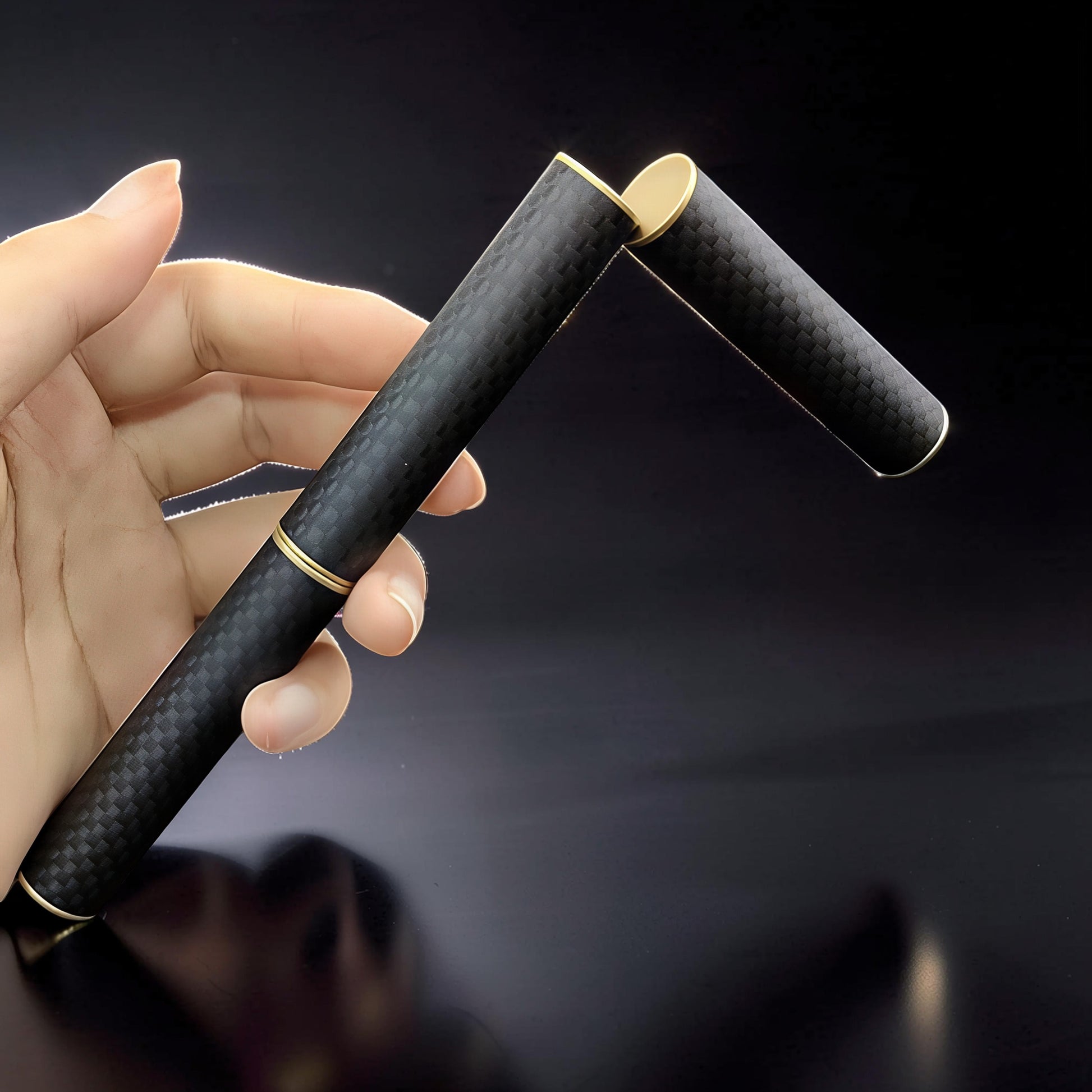 The Curious Mind Magnetic Carbon Fiber Slider with gold accents, held in a hand. Features a sleek black carbon fiber pattern and satisfying magnetic push-and-return action.