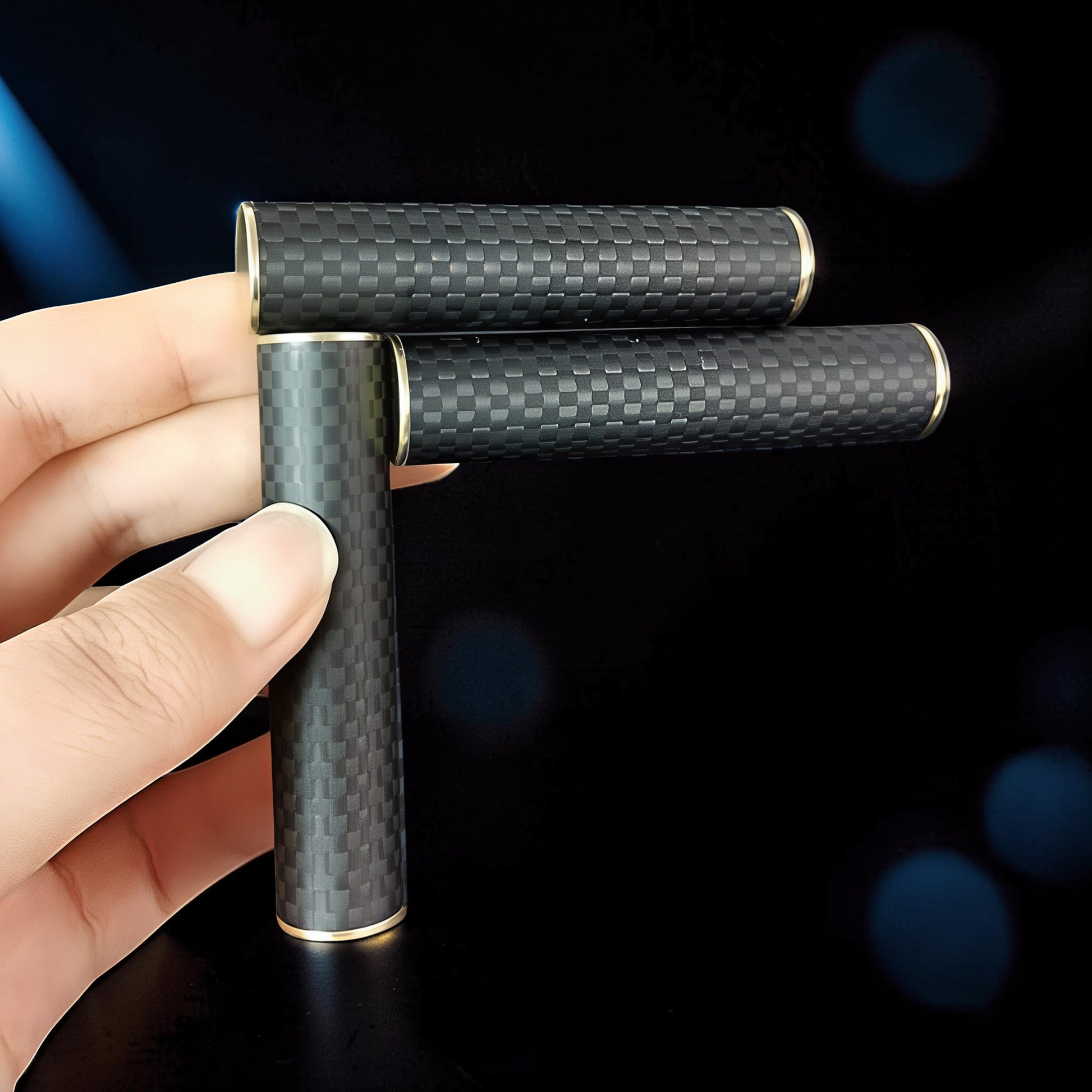The Curious Mind Magnetic Carbon Fiber Slider fidget toy with gold accents, held in a hand against a dark background.