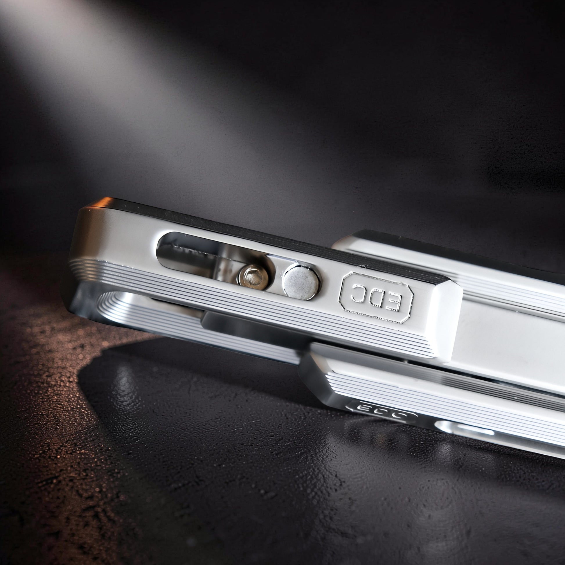 The Curious Mind premium magnetic double push slider fidget toy, made of silver metal with ribbed detailing and 'EDC' embossed.