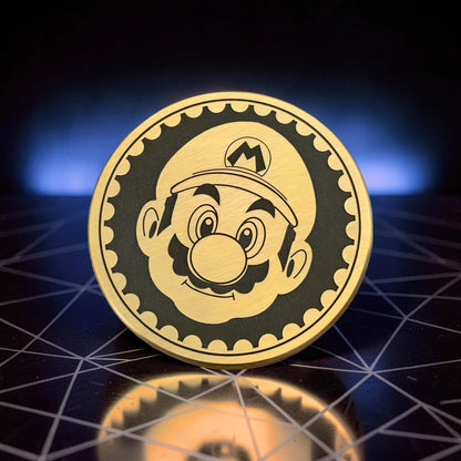 The Curious Mind Blacksmith Pop Coin Clicker featuring Mario's face, made of gold-tone metal with a black background.