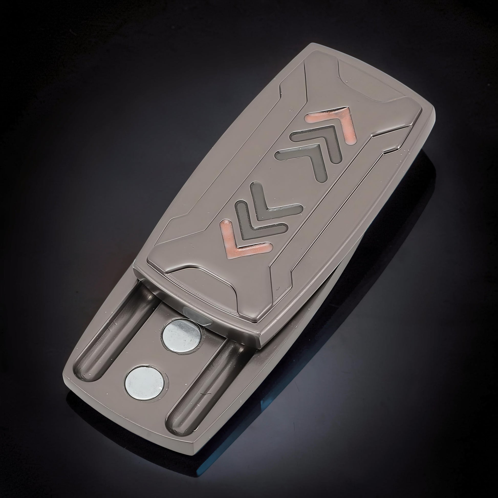 The Curious Mind Arrow Pusher Click Slider fidget toy, a compact metal slider with a gunmetal finish and arrow design. Features magnetic closure.