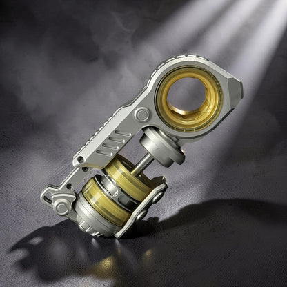 The Curious Mind Fork Ratchet Metal Slider fidget toy with silver and gold accents, featuring a compact push-and-return mechanism.