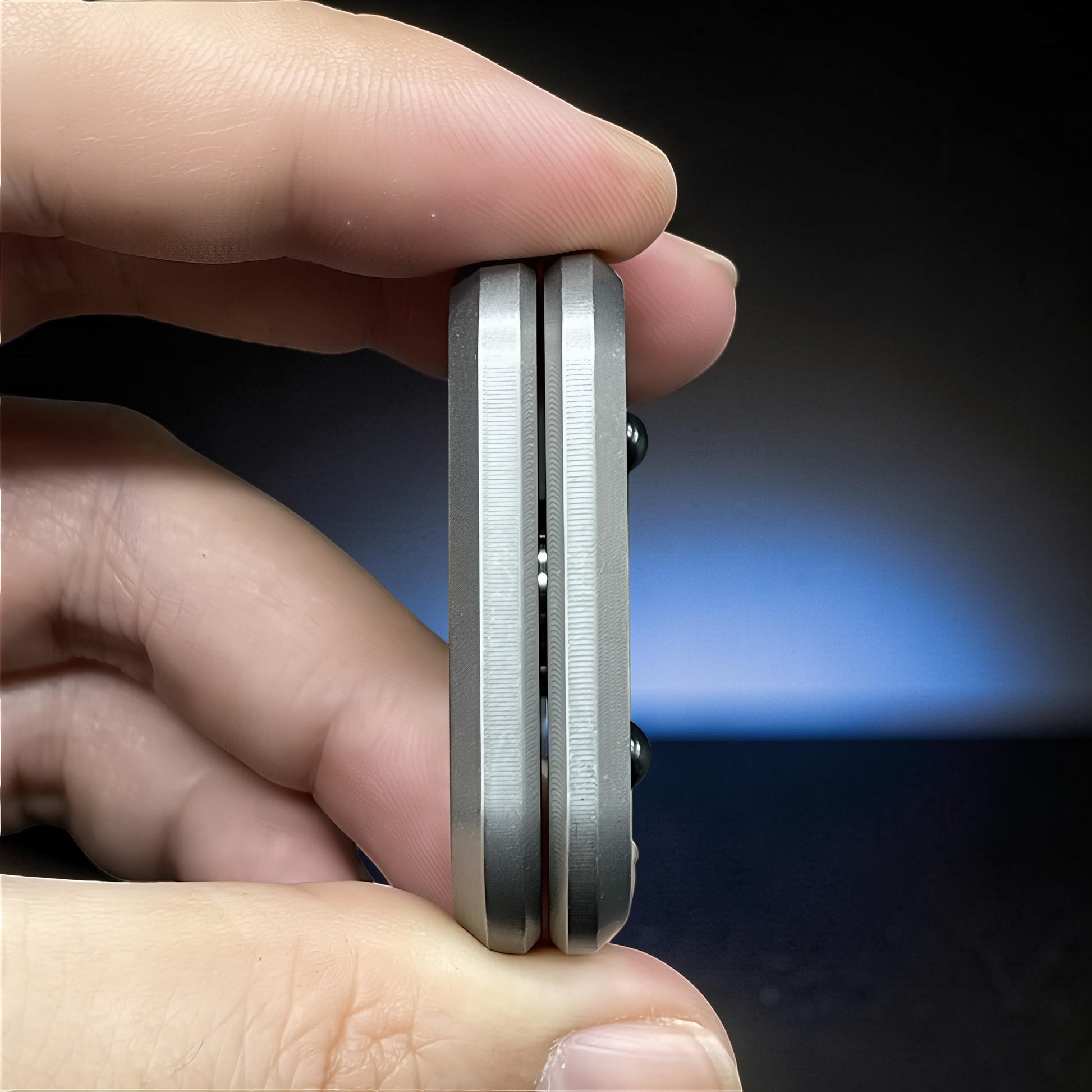 The Curious Mind Owl Push Slider, a compact metal fidget toy with a grey finish and satisfying push-and-return action.