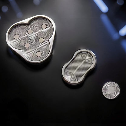 The Curious Mind triangle rotary push card fidget toy made of silver metal with circular grooves and magnetic elements.