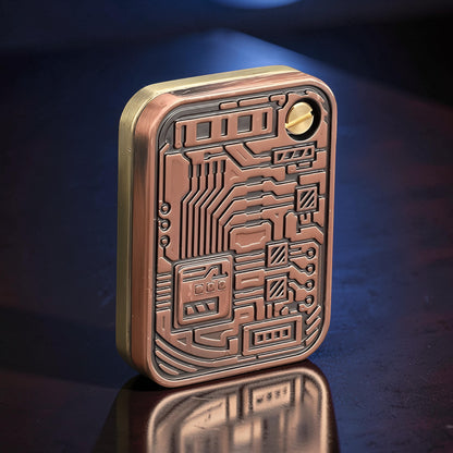 The Curious Mind Three-Body Push Card Fidget, a compact metal fidget toy with a copper and brass finish, featuring a detailed circuit board design for tactile stress relief.