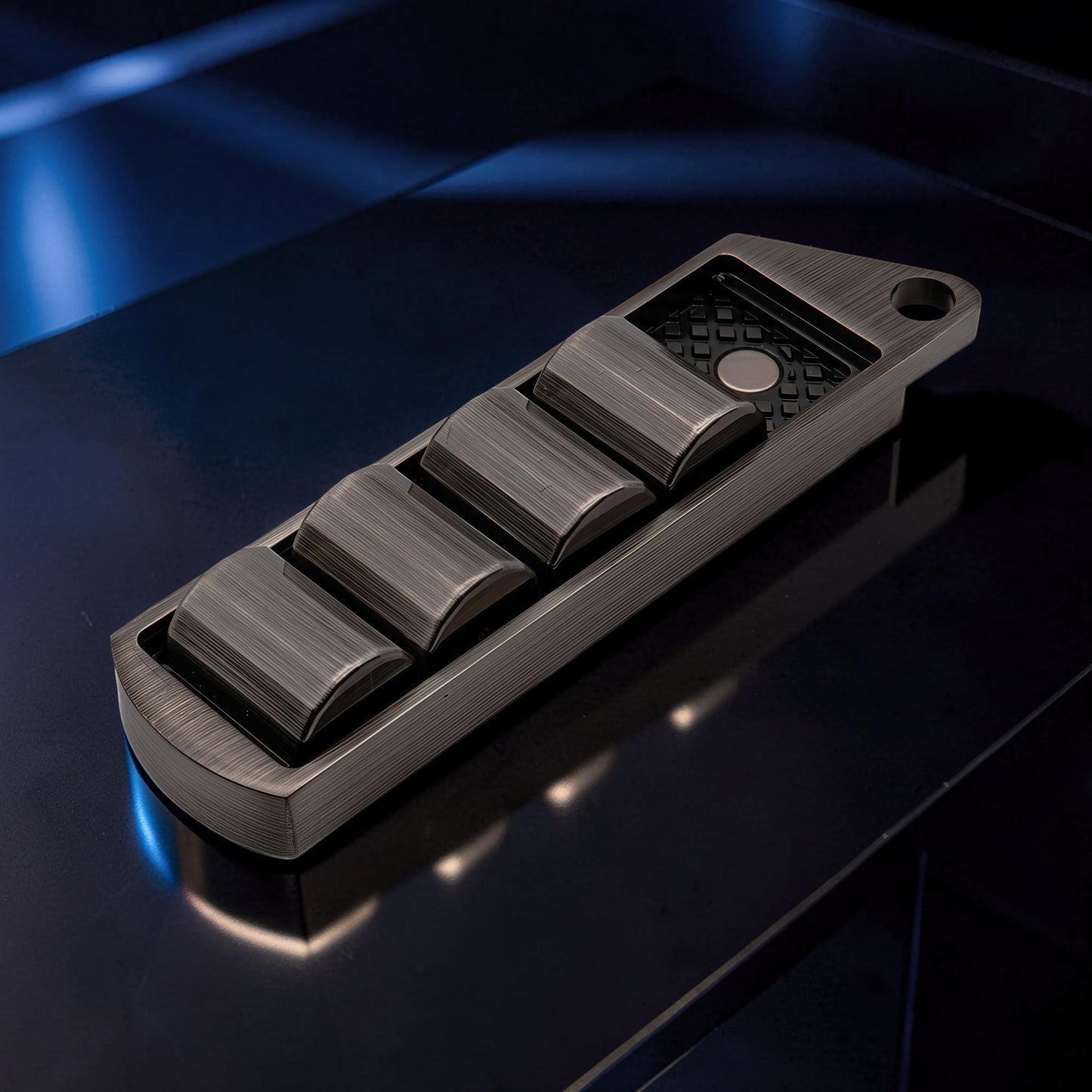 The Curious Mind Pea Pod Pop Coin Clicker, a metal fidget toy with four pods that click when pressed, in a gunmetal finish.