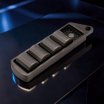 The Curious Mind Pea Pod Pop Coin Clicker, a metal fidget toy with four pods that click when pressed, in a gunmetal finish.