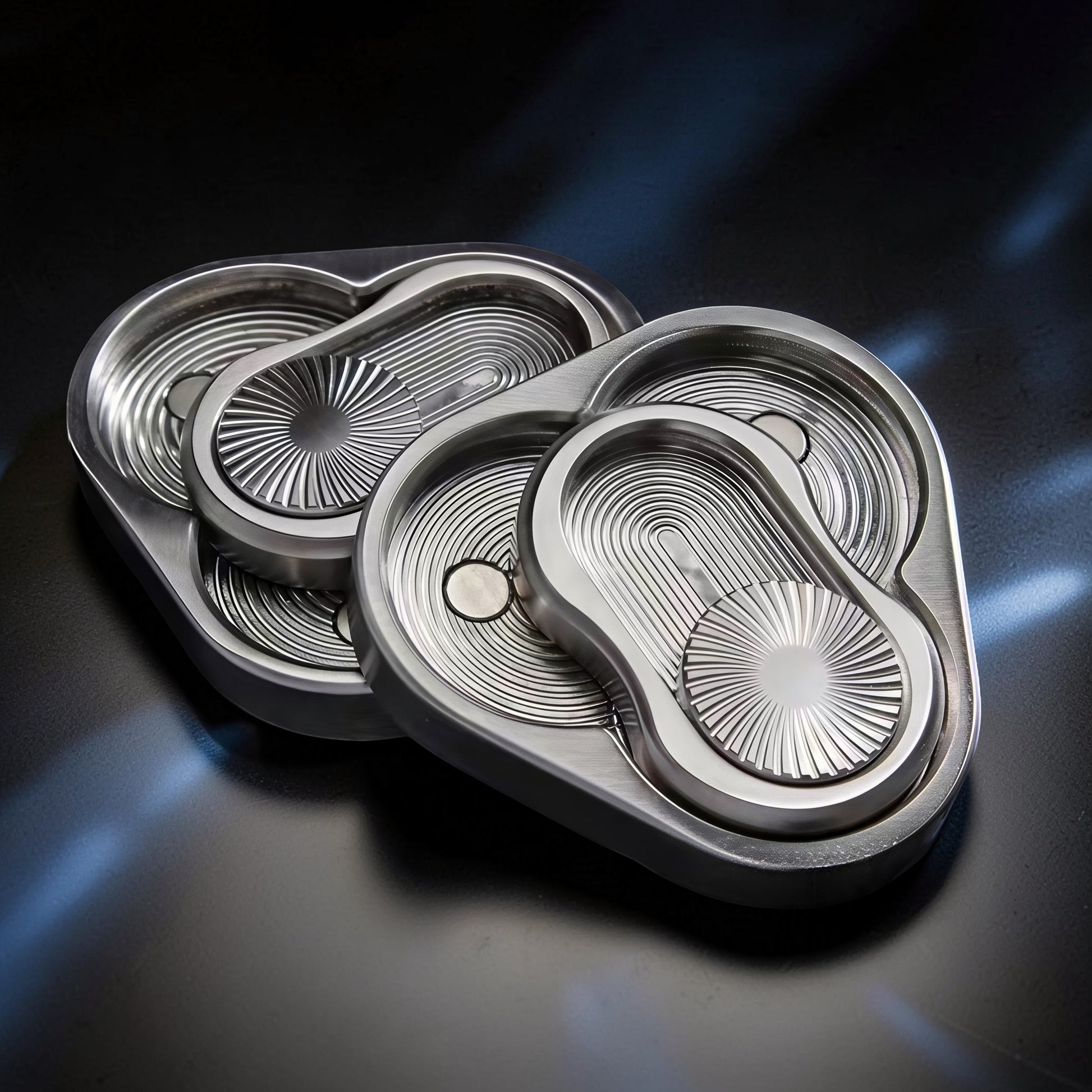 The Curious Mind Triangle Rotary Push Card fidget toy, made of brushed metal with a unique grooved design and satisfying push-and-return action.