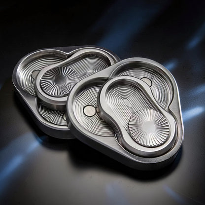 The Curious Mind Triangle Rotary Push Card fidget toy, made of brushed metal with a unique grooved design and satisfying push-and-return action.