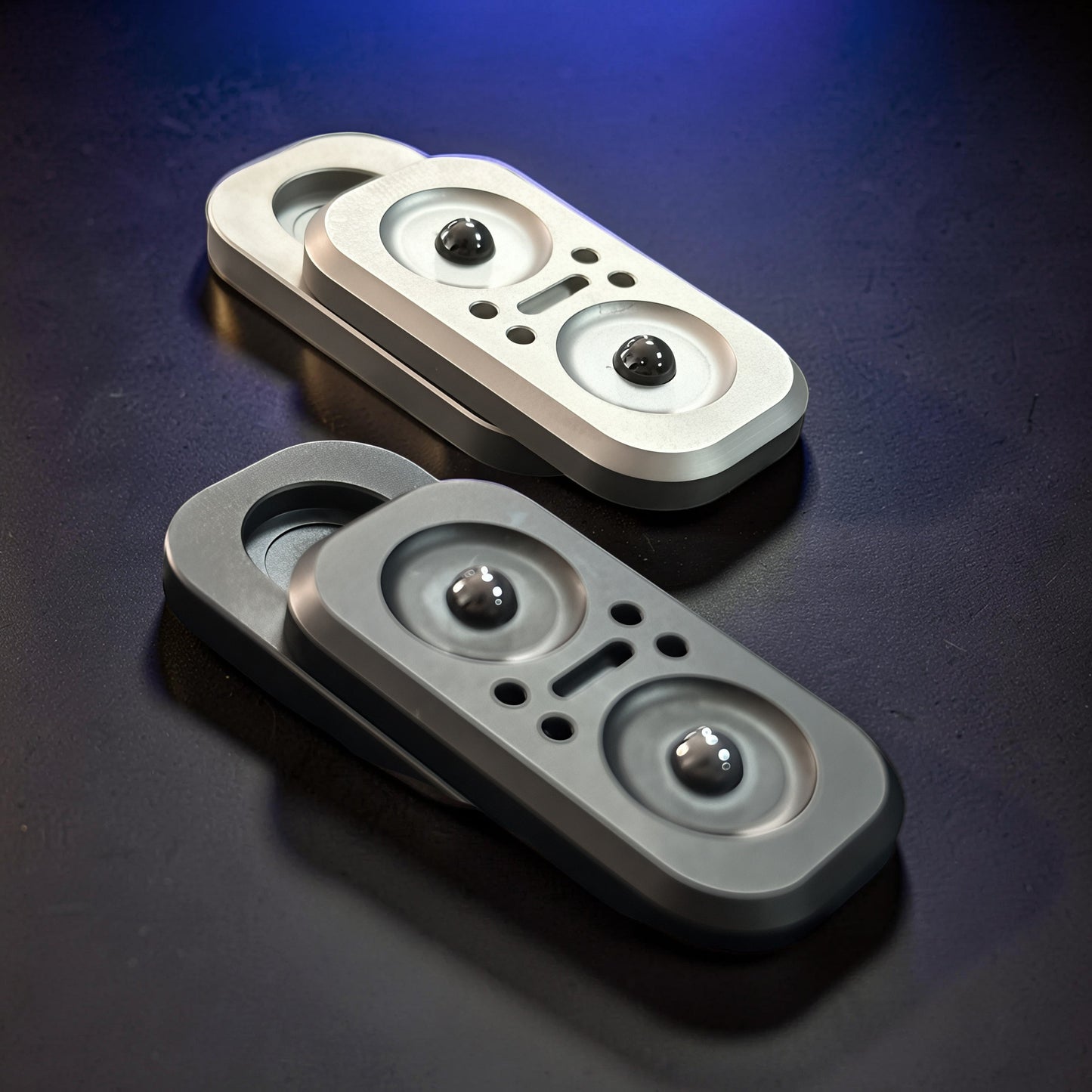 The Curious Mind Owl Push Slider fidget toy in silver and dark grey metal, featuring a compact design with two magnetic balls.