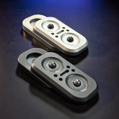 The Curious Mind Owl Push Slider fidget toy in silver and dark grey metal, featuring a compact design with two magnetic balls.