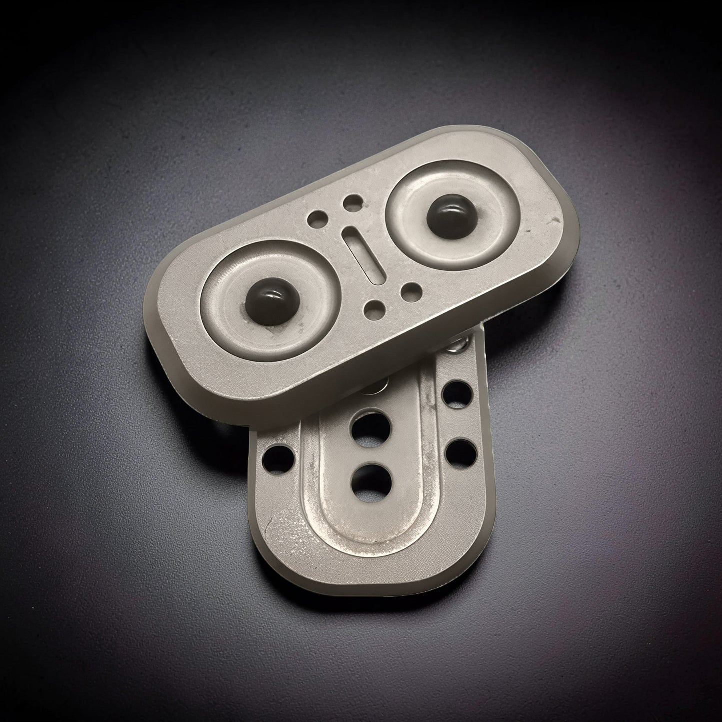 The Curious Mind Owl Push Slider, a compact metal fidget toy with a silver finish and dark green magnetic beads.