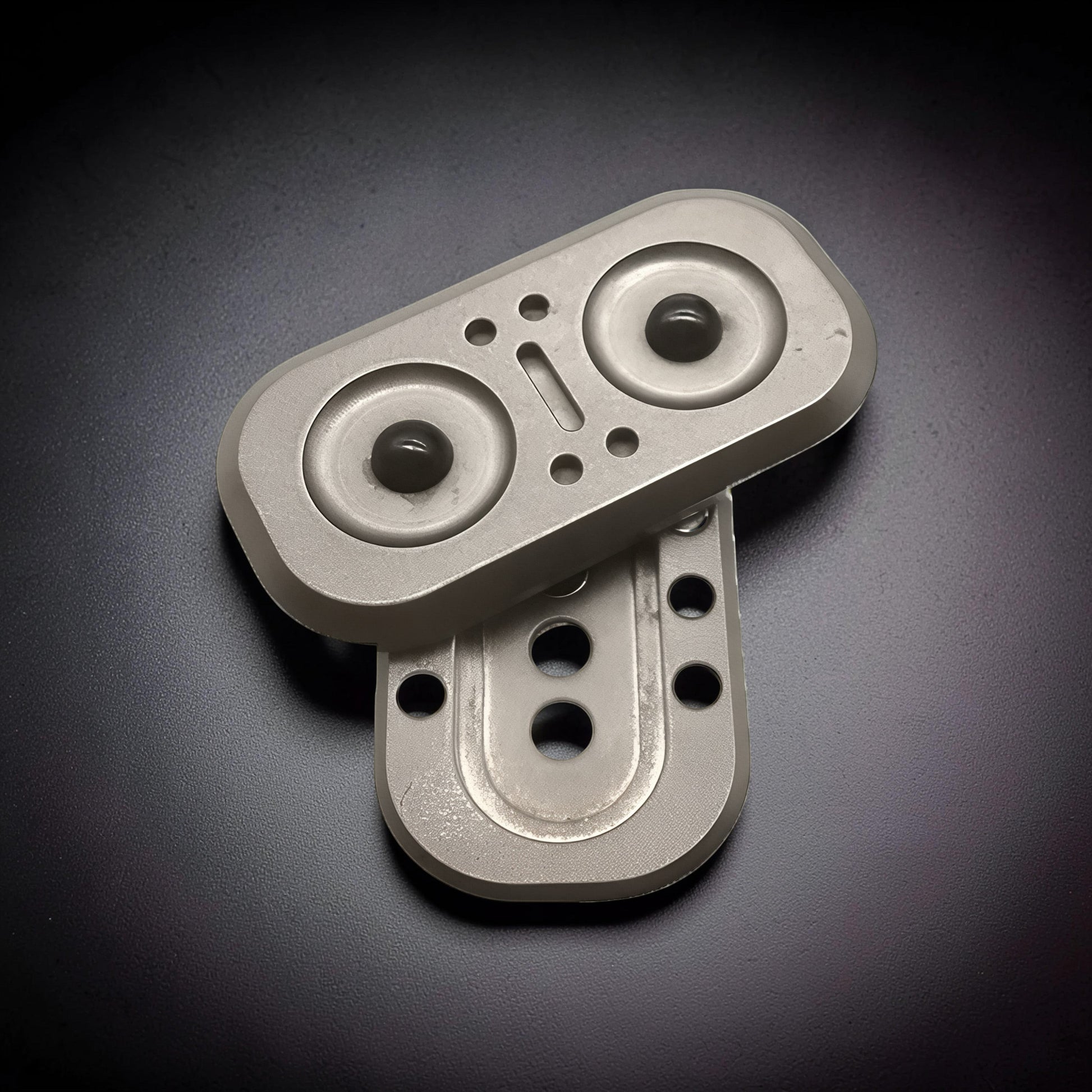 The Curious Mind Owl Push Slider, a compact metal fidget toy with a silver finish and dark green magnetic beads.