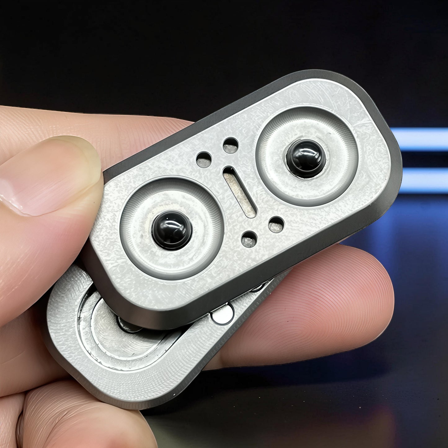 The Curious Mind Owl Push Slider fidget toy, made of brushed metal with black magnetic spheres and a compact, ergonomic design for stress relief.