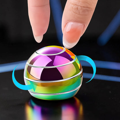 The Curious Mind high-gloss metal desktop stress ball with rainbow iridescent finish, shown being spun by fingers.